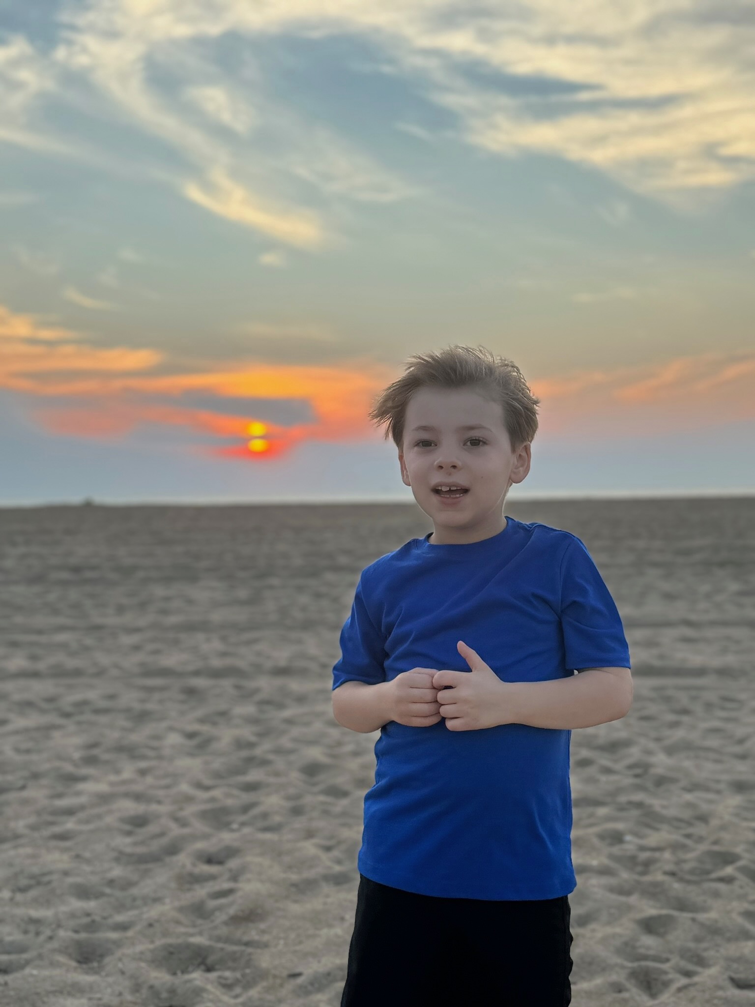 Noah on the sand as the sun sets behind him