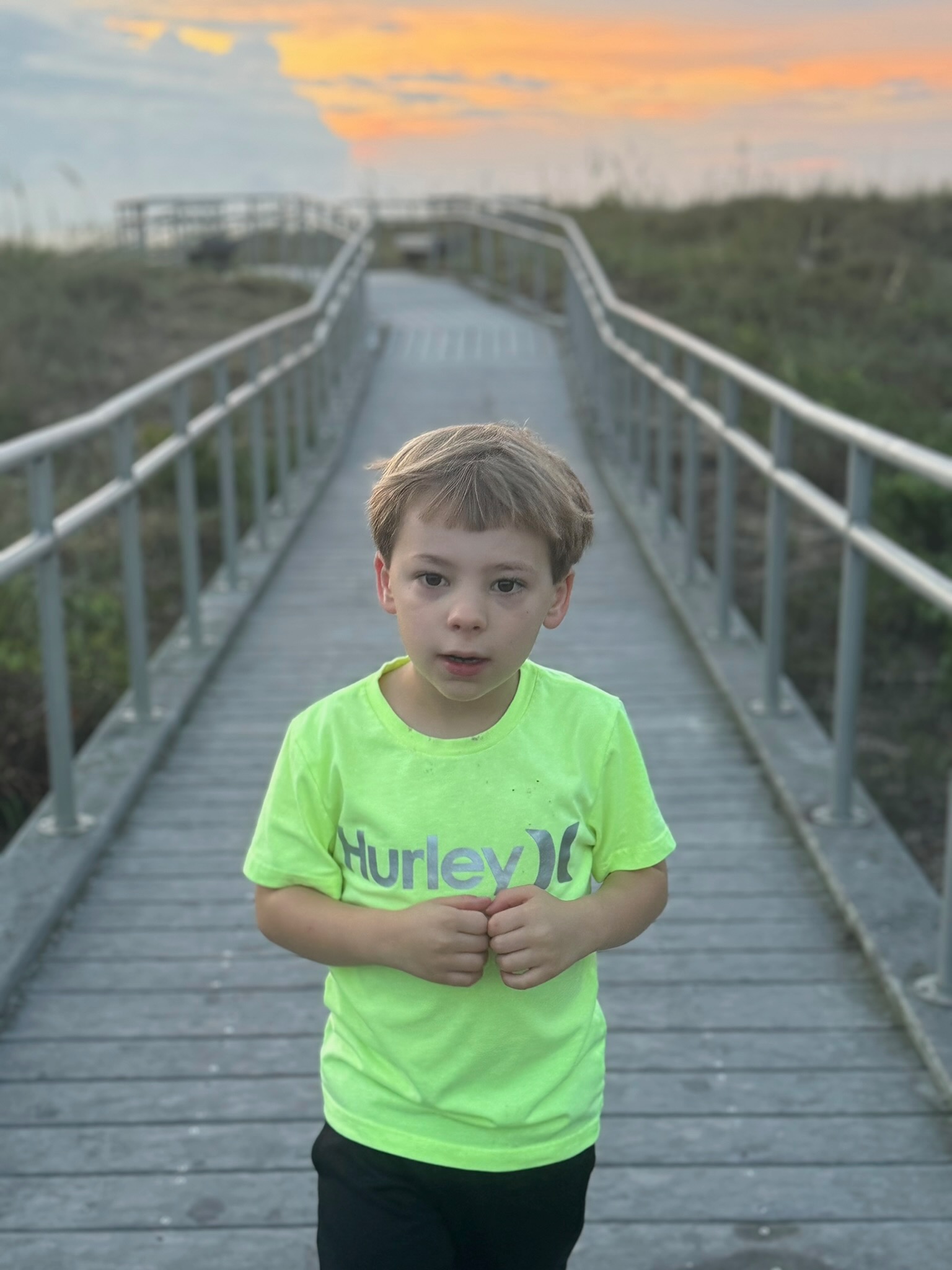 Noah on the beach boardwalk at sunset
